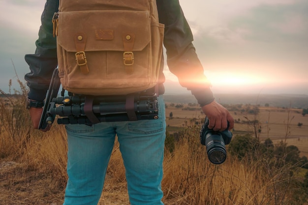 Een man met een camera die foto's maakt bij zonsondergang