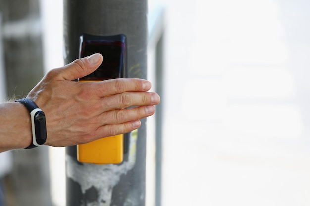 Foto een man met een fitnessarmband om zijn hand drukt op de alarmknop bij de onderneming