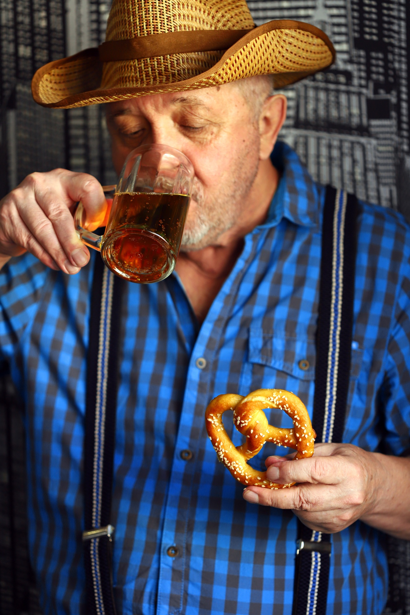 Een man met een glas bier en een krakeling. Oktoberfest-viering.