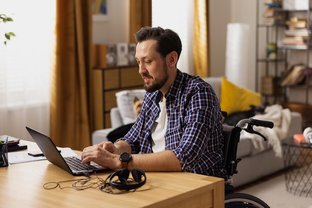 Een man met een handicap zit in zijn woonkamer nieuw hondenvoer te bestellen bij een internetwinkel