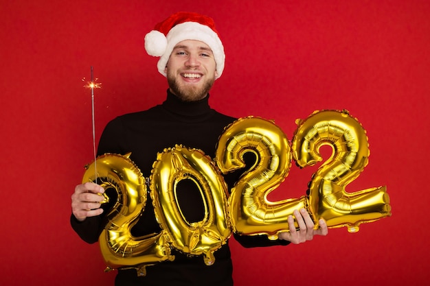 Een man met een kerstmuts houdt de nummers 2022 vast en een sterretje