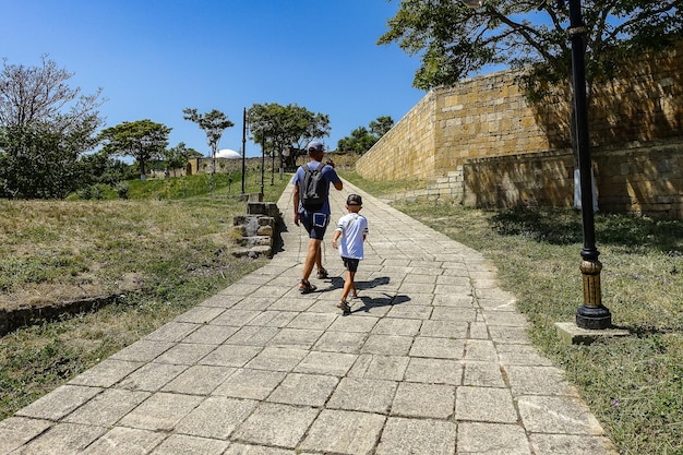 Een man met een kind op het grondgebied van het NarynKala-fort in Derbent Dagestan, Rusland juni 2021