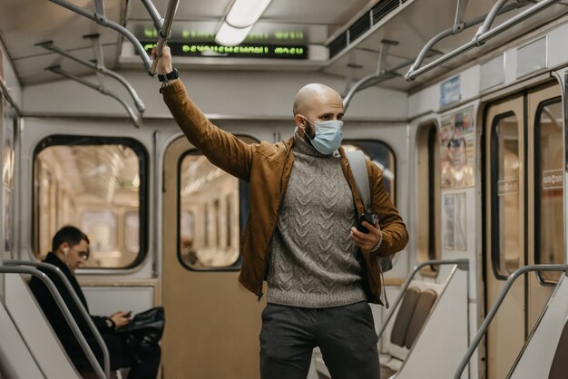 Een man met een medisch gezichtsmasker bij het metrostation