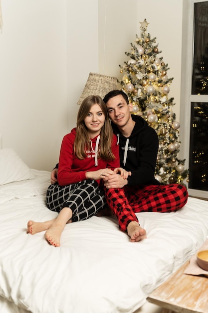 Een man met een meisje in pyjama die 's avonds op het bed knuffelt. kerst avond.