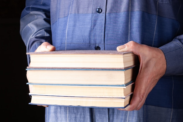 Een man met een stapel boeken