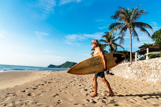 Een man met een surfplank aan de kust