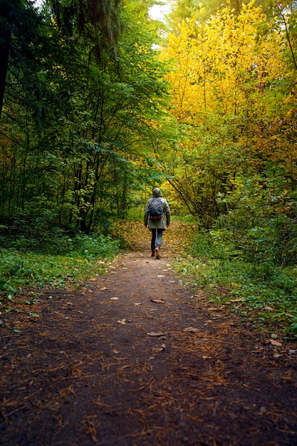 Een man met rugzak loopt in het verbazingwekkende herfstbos.