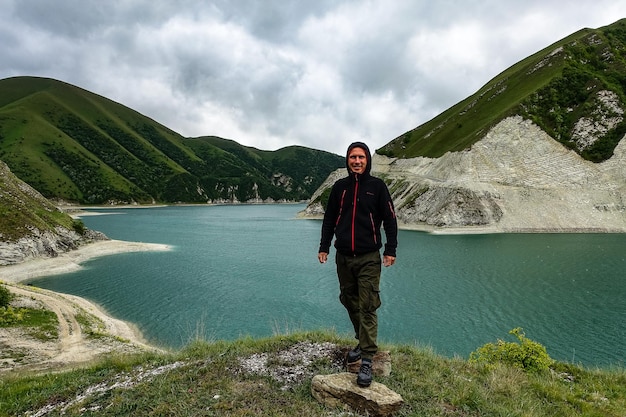 Een man op de achtergrond van het Kezenoyam-meer in de bergen van de Kaukasus in Tsjetsjenië, Rusland juni 2021