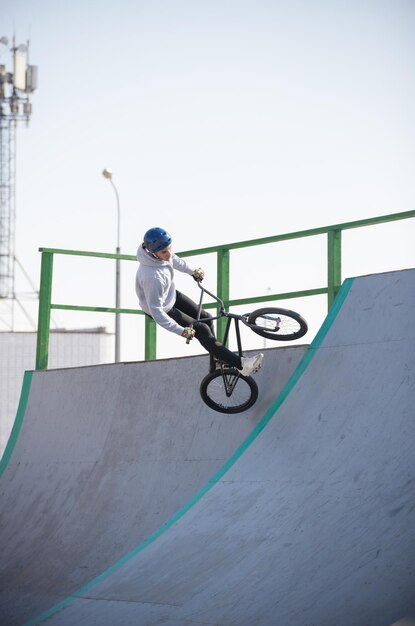 Een man op een fiets die een truc uithaalt op de halfpipes