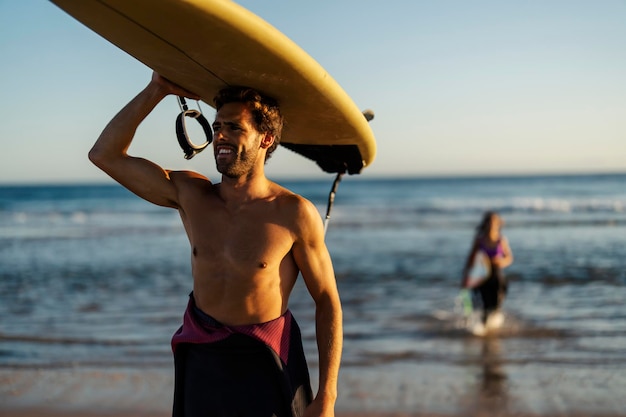 Een man op een strand die aan het surfen is