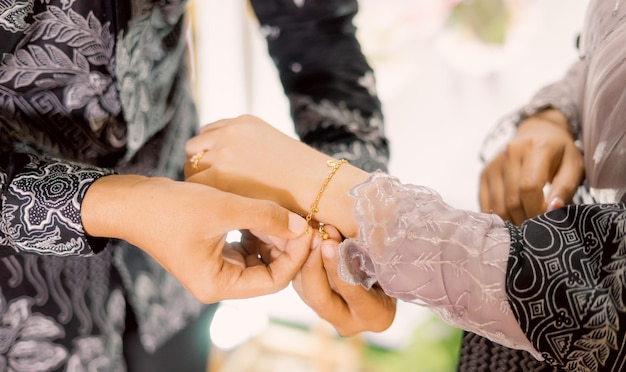 Een man plaatst een armband om de pols van een vrouw.