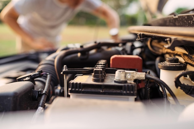 Een man probeert de auto op de weg te repareren