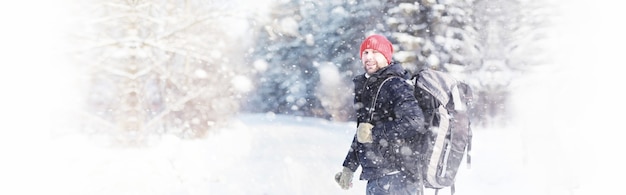 Een man reist met een rugzak. Winterwandeling in het bos. Toerist op een wandeling in de winter in het park.