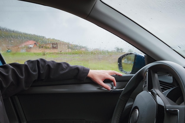 Een man rijdt in de regen op de weg