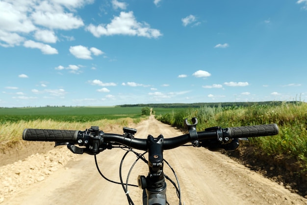 Een man rijdt op een fiets en in de camera rijdt een man op een fiets in een veld