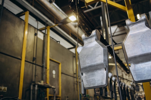 Een man schildert een detail voor straatverlichtingstransportband van straatverlichtingsproductie in de fabriek