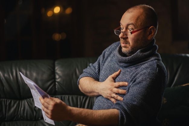 Een man schrikt van een papieren brief Slecht nieuws leidt tot stress Belastingverhoging slechte communicatie