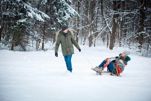 een man sleedt zijn vrouw in de sneeuw in de winter Geluk zit in simpele dingen