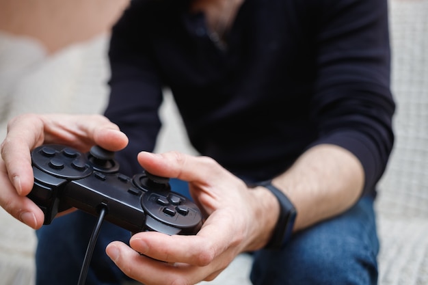 Een man speelt videogames met een joystick in zijn handen