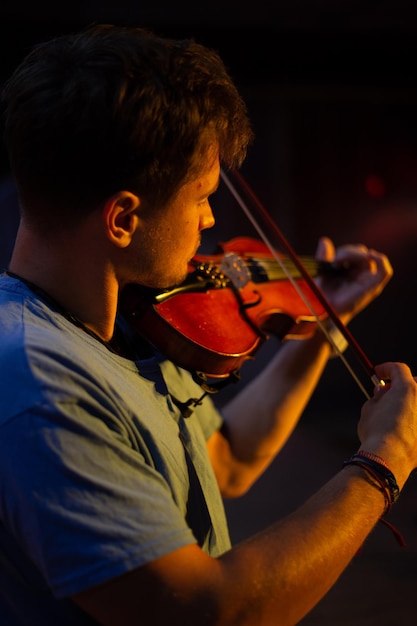 Een man speelt viool op het toneel van close