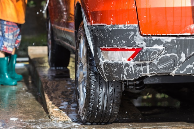 Een man spuiten hogedrukreiniger voor carwash in autoverzorging