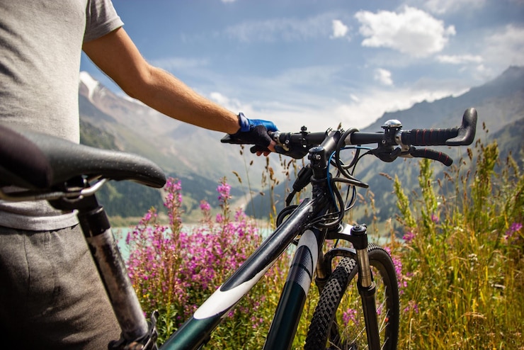 Foto een man staat naast een mountainbike op de achtergrond van een bergmeer
