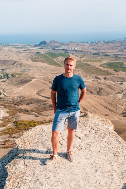 Een man staat op een rots in de Koktebel-vallei op de Krim