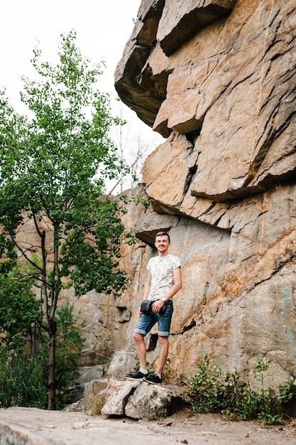 Een man staat op het oppervlak van de grote rotsmuur op een grote steen