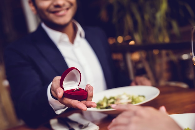 Een man stelt een vrouw voor en geeft haar een ring.