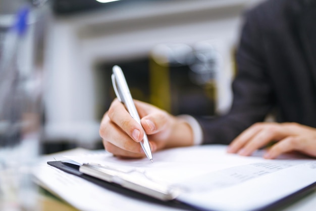 Een man tekent een contract juridische of zakelijke overeenkomsten mannenhand met pen van kantoormedewerker maakt aantekeningen