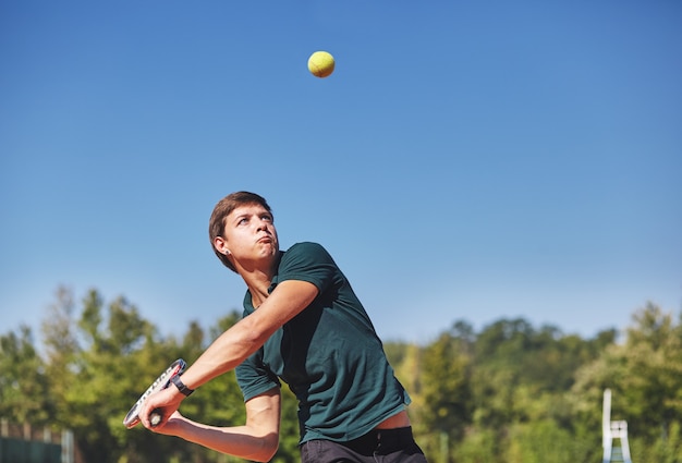 Een man tennissen op de baan op een mooie zonnige dag