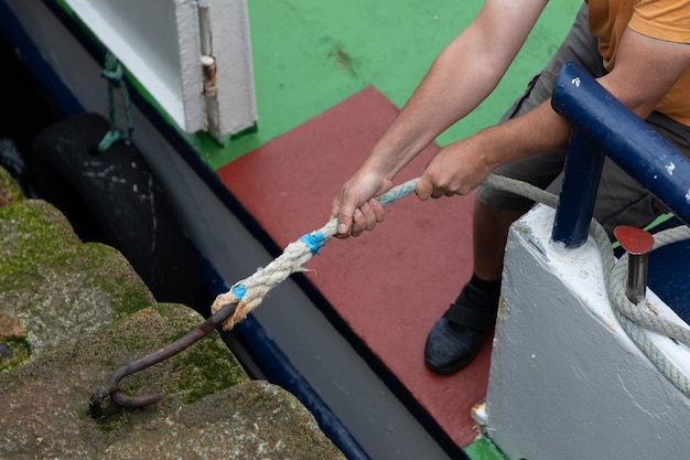 Een man trekt een groot anker uit een boot.