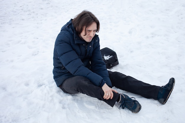 Een man valt in de sneeuw. De man gleed uit en raakte gewond