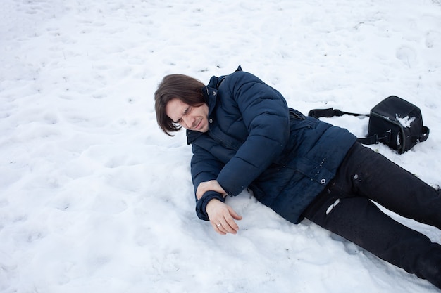 Een man valt in de sneeuw. De man gleed uit en raakte gewond