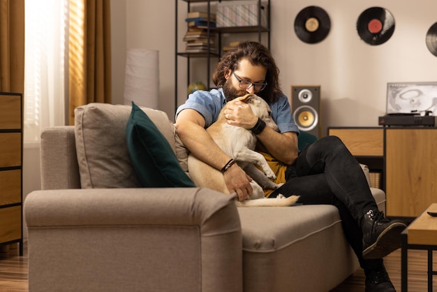 Een man van middelbare leeftijd knuffelt zijn hond na thuiskomst van zijn werk een hondenbezitter begroet zijn huisdier na thuiskomst f