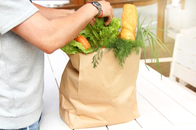 Een man verpakt gezonde groenten in een consumentenpakket