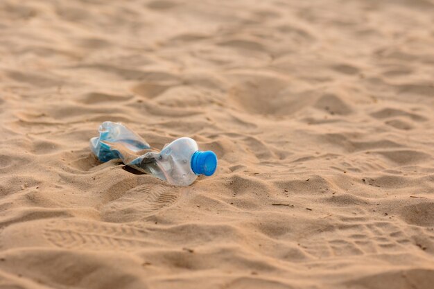 Een man verzamelt plastic flessen en afval op het strand op een openbare plaats, milieuvriendelijk en zorgzaam