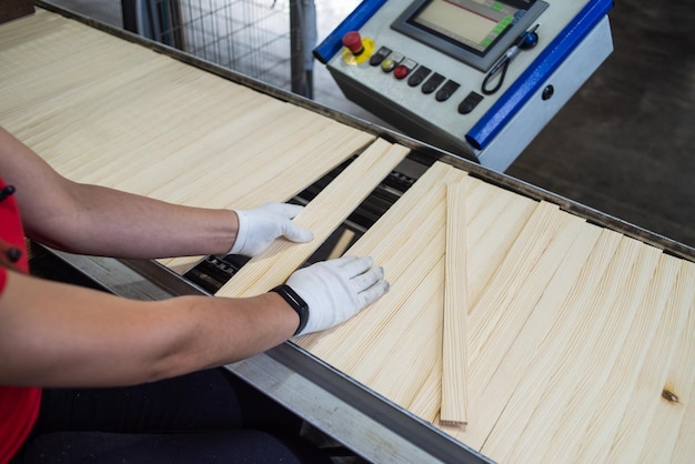 een man werkt aan een houten plank met een machine op de achtergrond