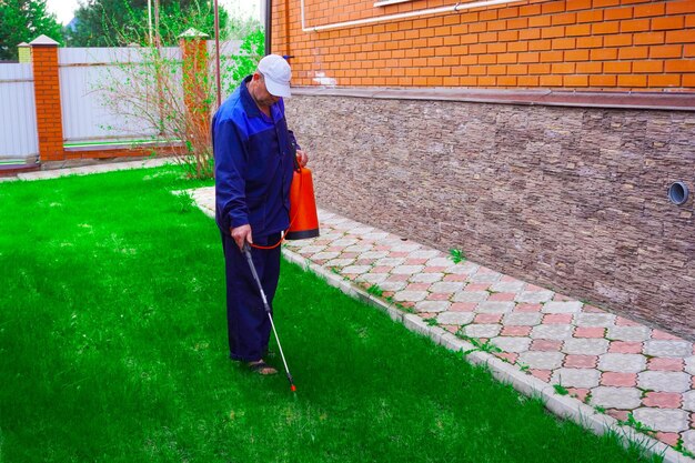 Foto een man werkt in de tuin met het sproeien van onkruid met een sprayer