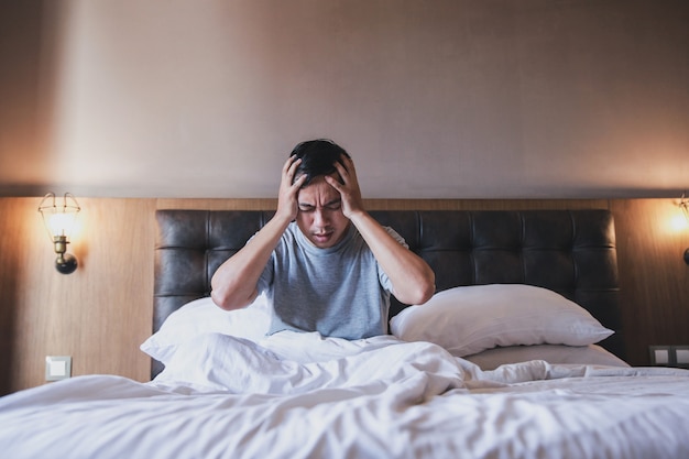 Een man wordt wakker uit zijn slaap en voelt hoofdpijn of migraine