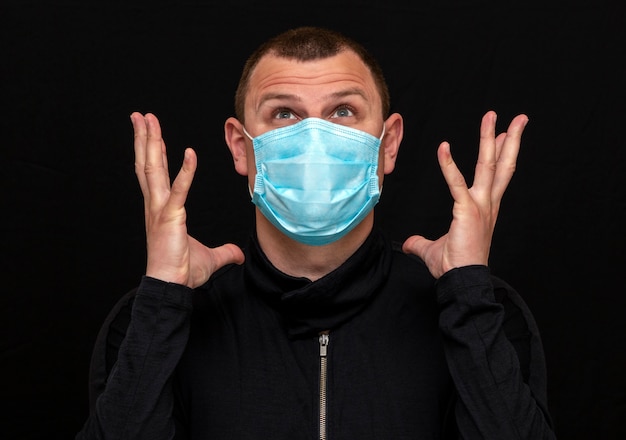 Een man zet een medisch masker op zijn gezicht, instructies voor het dragen van een masker