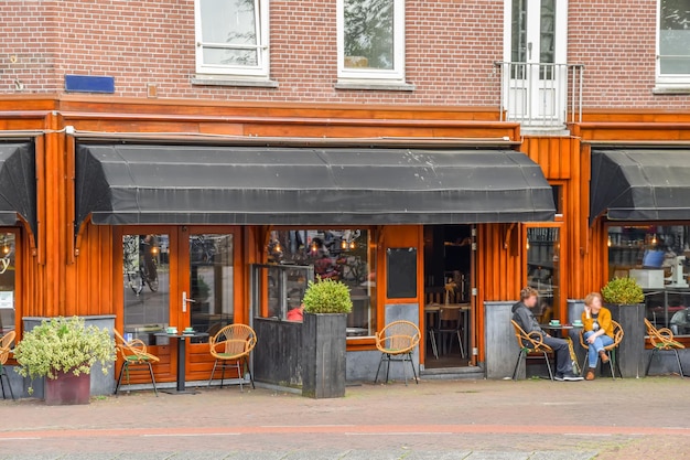 Foto een man zit aan een tafel buiten een restaurant