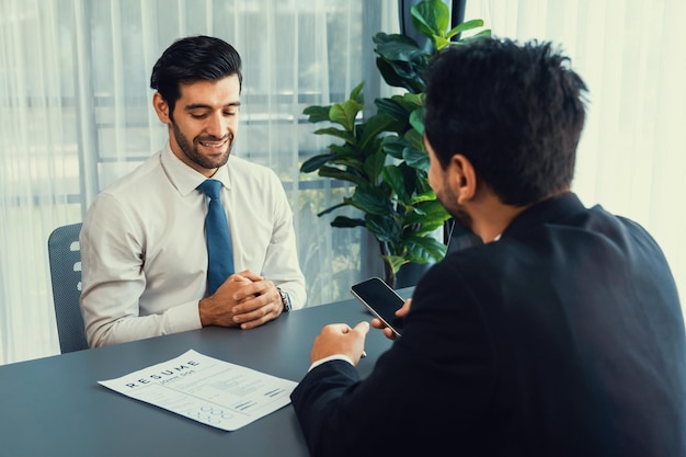 Een man zit aan een tafel met een document waarop staat 'ik ben een bank'.