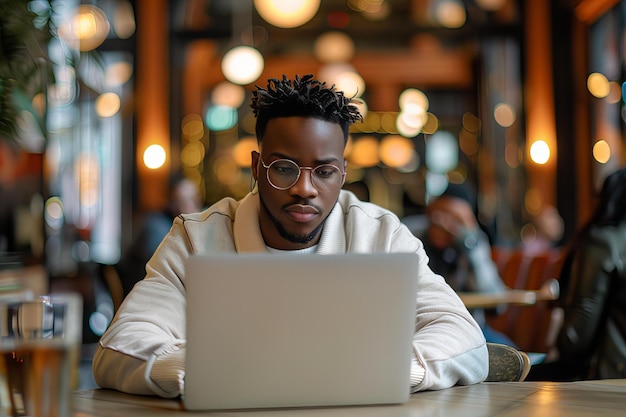 Een man zit aan een tafel met een laptop.