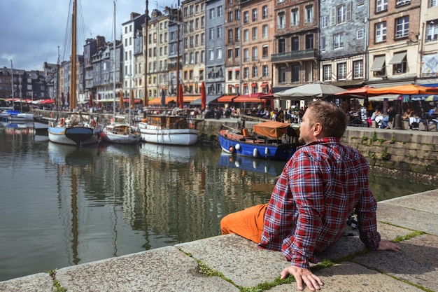 Een man zit op de achtergrond beroemde franse stad honfleur normandië frankrijk