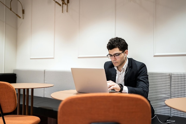 Een manager met een bril in informele kleding werkt in een kantoor in een coworking