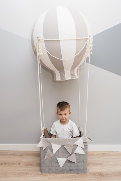 Een mand met een grijze ballon het decor van een kinderkamer en vakantie een jongen in de ballon