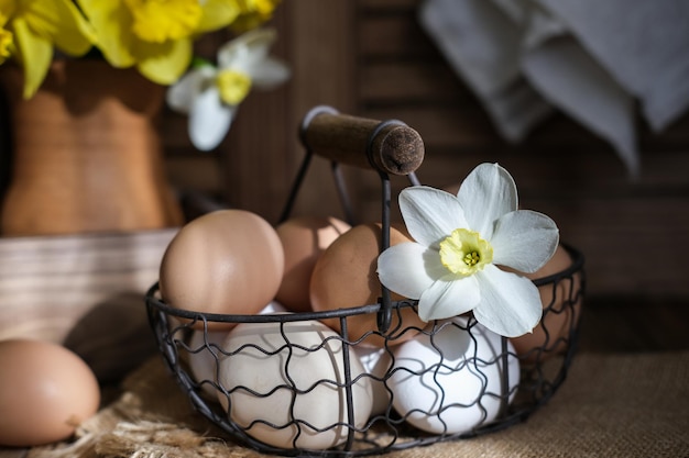 Een mand met eieren en een vaas met narcissen Paasstilleven in rustieke stijl