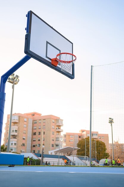 Een mand op een straatbasketbalveld bij zonsondergang