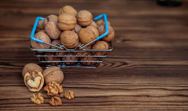 Een mand vol walnoten op een houten achtergrond